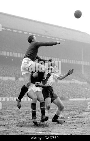 Manchester United goalkeeper Harry Gregg punces the ball away over the heads of Tottenham inside-left Dunmore ans a manchester defender, during the first division match. Stock Photo