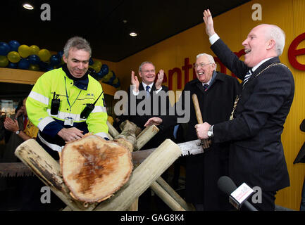 Belfast Lord Mayor Jim Rodgers (right) saws a log to officially open Ireland's first IKEA store, in Belfast, watched by Northern Ireland First Minister Ian Paisley (second right) and Deputy First Minister Martin McGuinness (second left). Stock Photo