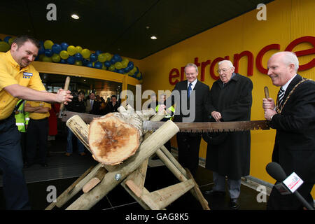 Belfast Lord Mayor Jim Rodgers (right) saws a log to officially open Ireland's first IKEA store, in Belfast, watched by Northern Ireland First Minister Ian Paisley (second right) and Deputy First Minister Martin McGuinness (second left). Stock Photo