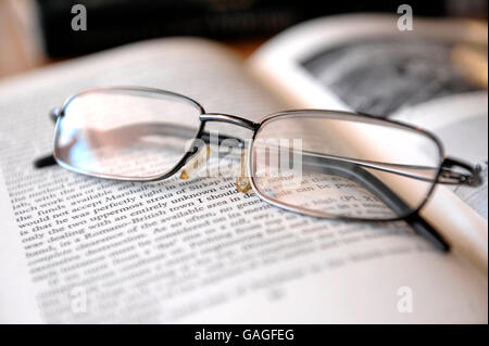 Reading glasses on top of book of antiquity Stock Photo