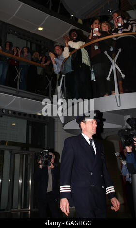 British Airways senior first officer John Coward walks past BA staff before captain Peter Burkill, 43, read out a statement about the crash-landing of the Boeing 777 at Heathrow. Stock Photo