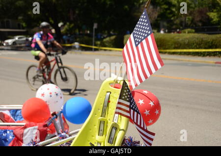 A bicyclist rides past a decorated bicycle after the Fourth of July parade in Ross, California in Marin County. Stock Photo