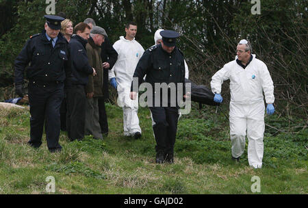 Missing woman Maura Reynolds son George and Daughter in law Priscilla watch as forensic experts remove a body from the scene at Bray Head, Co Wicklow, Ireland. Stock Photo