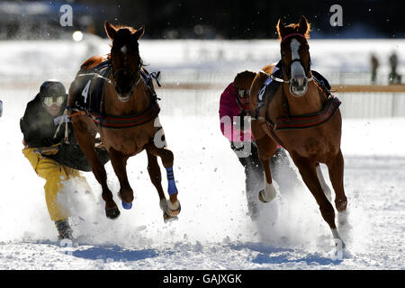 Horses race over the compacted ice and snow on the frozen lake at St Moritz on the first White Turf racing day of 2008. Stock Photo