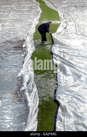 Soccer - FA Barclaycard Premiership - Charlton Athletic v West Ham United. Groundsmen at Charlton Athletic cover the pitch up after the game was called off for a waterlogged pitch Stock Photo