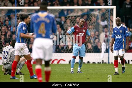 Soccer - Barclays Premier League - Portsmouth v Aston Villa - Fratton Park. Portsmouth players celebrate as Aston Villa's Nigel Reo-Coker (centre) stands dejected after scoring an own goal Stock Photo