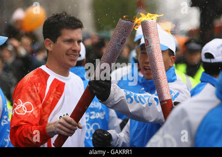 British tennis player Tim Henman carries the Olympic torch during its relay journey across London on its way to the lighting of the Olympic cauldron at the O2 Arena in Greenwich. Stock Photo