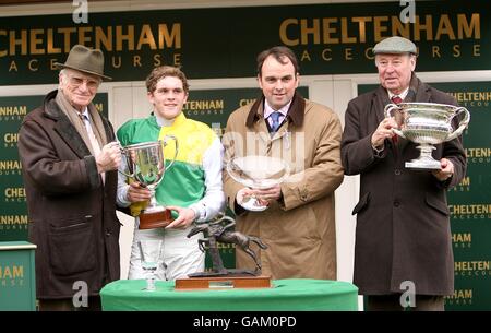 Trainer Alan King (second right), jockey Charlie Huxley (second left) and owner Trevor Hemmings (r) with former racing commentator Peter O'Sullivan (l) after winning in the Peter O'Sullevan National Hunt Chase Challenge Cup during the Cheltenham Festival Stock Photo