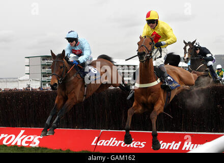Jockey Joe Tizzard on Joe Lively (yellow /red) from Sam Thomas on Silverburn in the Royal and Sun Alliance Steeple Chase during the Cheltenham Festival at Cheltenham Racecourse. Stock Photo