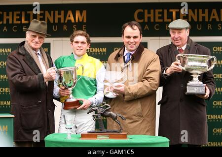 Trainer Alan King (second right), jockey Charlie Huxley (second left) and owner Trevor Hemmings (r) with former racing commentator Peter O'Sullivan (l) after winning in the Peter O'Sullevan National Hunt Chase Challenge Cup during the Cheltenham Festival. Stock Photo