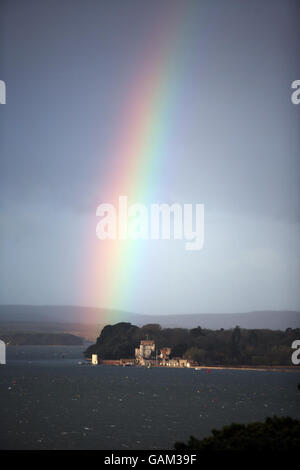 A rainbow over Branksea Castle (also known as Brownsea Castle) in Poole harbour, Dorset, as storm clouds gather. Stock Photo