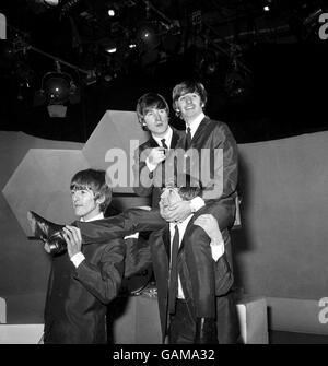 Beatles drummer Ringo Starr on the shoulders of Paul McCartney at the BBC's Lime Grove studios on his 24th birthday. Other Beatles are, left to right, George Harrison and John Lennon. Stock Photo