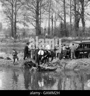 A Rolls Royce technical team, Airline officials and Army and navy experts inspect the Boeing 707 jet engine which plummeted into a flooded gravel pit at Thorpe, Surrey, just before the crippled airliner crash-landed at Heathrow Airport, London. Royal Navy frogmen from HMS Vernon located the engine at a depth of 40 feet and the Army winched the engine ashore. Stock Photo