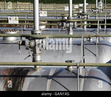 many giant shut-off valves and piping above the pressure vessel of a plant for the storage of natural gas Stock Photo