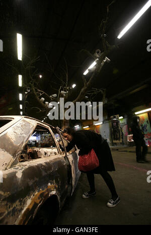 A visitor inspects 'Tree', an artwork by graffiti artist Banksy at the 'Cans festival' in a road tunnel in Leake Street, Lambeth, London. Stock Photo