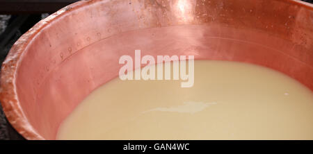 large copper pot with the milk and the whey for the production of cheese Stock Photo
