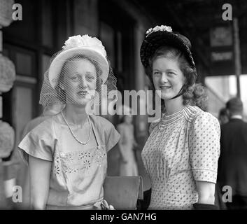 Miss I Coppock, left, wears a veiled hat and Mrs. S McCash wears a bonnet at Royal Ascot. Stock Photo