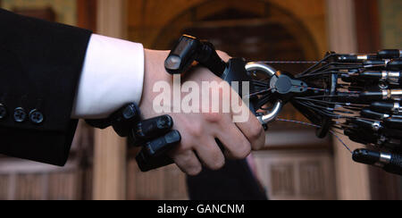 A person shakes hands in the House of Commons, London, with Shadow Robot Company's C5 Dexterous Hand. The only robot hand in the world that is capable of the same movements as the human hand, which is being developed for industrial applications. Stock Photo