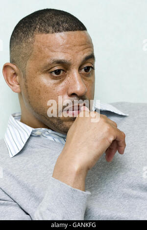 Kenneth Charlery, the father of KC Jnr who was left brain damaged and partially paralysed after a shooting incident in Hackney, listens during an interview with a reporter at Hackney Police Station, London. Stock Photo