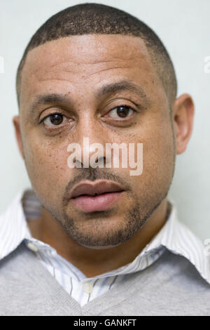 Kenneth Charlery, the father of KC Jnr who was left brain damaged and partially paralysed after a shooting incident in Hackney, listens during an interview with a reporter at Hackney Police Station, London. Stock Photo