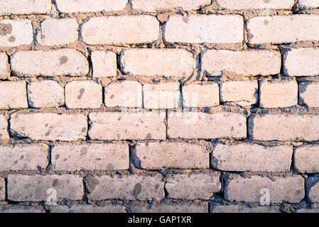 Old faded home brick wall in natural sunlight with copyspace area Stock Photo