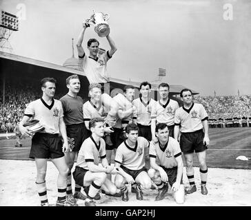 Wolverhampton Wanderers captain Bill Slater holds the FA Cup aloft as he is chaired by his jubilant teammates: (back row, l-r) Gerry Harris, Malcolm Finlayson, Ron Flowers, Peter Broadbent, Eddie Clamp, George Showell and Norman Deeley. (Front row, l-r) Barry Stobart, Des Horne and Jimmy Murray. Stock Photo