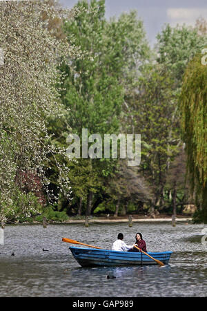 A couple enjoy the sunshine on the boating lake in Regent's Park, London. Stock Photo