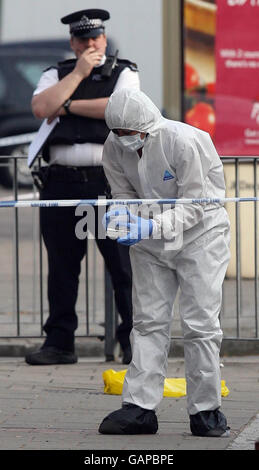 Police forensics officers at the scene where a teenage boy was murdered at the Three Cooks bakery in Lee, south east London. Stock Photo