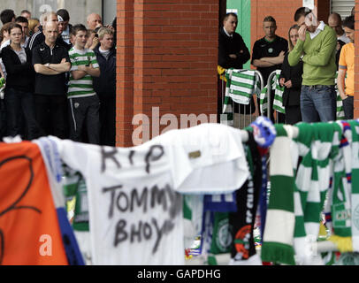 Celtic's Stephen McManus (right) with tributes which have been left for Tommy Burns at Celtic Park, Glasgow. Stock Photo