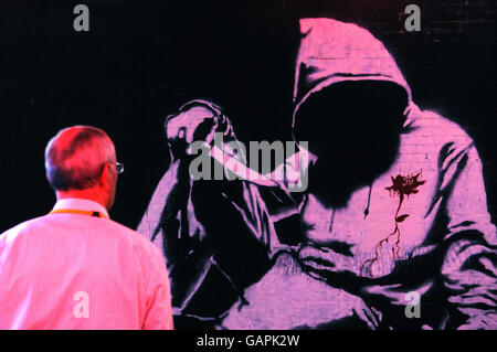 A person views a piece depicting a hoodie in a tunnel near Waterloo, London, which has been turned into giant exhibition space called Cans Festival by graffiti artist Banksy and other artists. Stock Photo