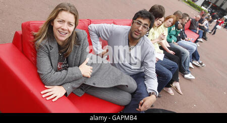 Comedian's Karen Daunbar and Sanjeev Kohli, sit on the world's longest sofa in Glasgow's George Square to promote Maggie's cancer charity. Stock Photo