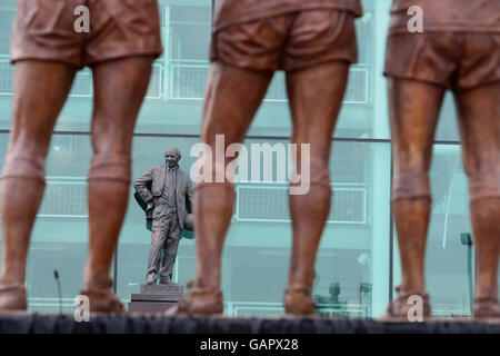 The statue of former manager Sir Matt Busby stands opposite the new Manchester United 'Holy Trinity' statue at Old Trafford, Manchester. Stock Photo