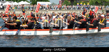 The crew of a Chinese dragon boat in action during the annual London Dragon Boat Festival at the Royal Albert Docks in east London. Stock Photo