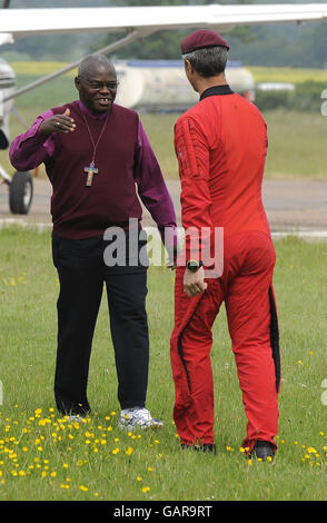 The Archbishop of York, Dr John Sentamu (left) prepares to board an aircraft to take part in a sponsored parachute jump, with a member of the Red Devils parachute display team over Langar Airfield in Nottinghamshire. Stock Photo