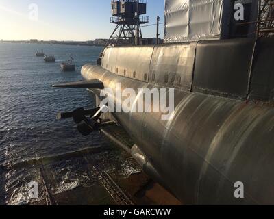 Black HMAS Ovens Submarine with Indian Ocean view dry docked outside the Maritime Museum in Fremantle,Western Australia. Stock Photo