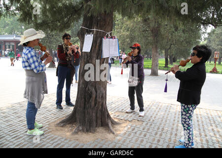 Women play a Cucurbit Flute Bottle or Bottle Gourd Silk, a typical Yunnan province instrument made of Gourd and bamboo. Temple of Heaven Park, Beijing Stock Photo