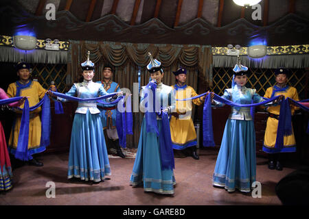 Mongolian dancers and singers, men and women, wear Mongolian costumes and perform to guests at the 99 Mongolian Yurts Restaurant. Beijing, China. Stock Photo