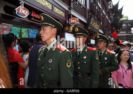 Uniformed Chinese soldiers walk in the crowd of tourists in the historical Yuyuan quarter. Shanghai, China. Apr., 2016. Stock Photo