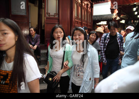 Young and happy Chinese women and many other tourists walk in the historical Yuyuan neighborhood. Shanghai, China. Apr., 2016. Stock Photo