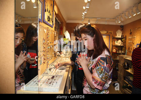 Two young Chinese women look at jewelry in a small jewelry shop in the Tianzifang area, the Former French Quarter. Shanghai. Stock Photo