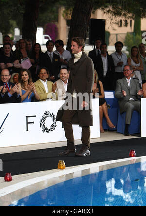 Prince Albert of Monaco, Liz Hurley, Arun Nayar and David Furnish watch as Jenson Button walks down the catwalk during the Grand Prix and Fashion Unite at The Amber Lounge, Le Meridien Beach Plaza Hotel, Monaco. Stock Photo