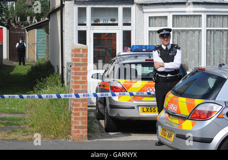 A Police Officer outside Number 111, Park Lane, in Carshalton where a five-year-old boy and a four-year-old girl have died from suspected stab wounds. A six month old baby girl has been left critically injured. A man and woman have been arrested. Stock Photo