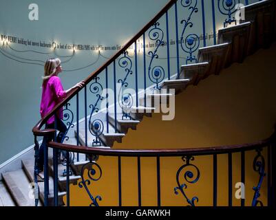 A Somerset House employee walks up Somerset House's Nelson staircase past Joseph Kosuth's 'A Grammatical Remark, 2016' an installation featuring the transcript of the confrontation between Jack and Wendy in The Shining, during a press preview of Daydreaming with Stanley Kubrick at Somerset House in London. Stock Photo