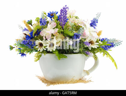 Table floral arrangement made of artificial flowers and cottons balls in stylized ceramic vase in form of tea cup isolated on wh Stock Photo