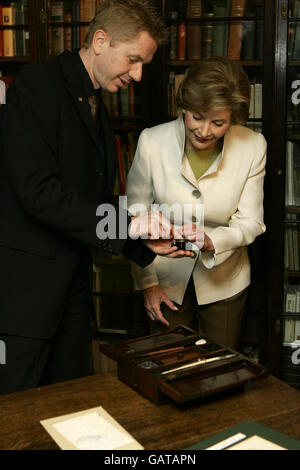 America's First Lady, Laura Bush, right, is shown Charles Dickens inkwell by Andrew Xavier, the museum director, during her visit to the Charles Dickens Museum in Doughty Street, London. Stock Photo