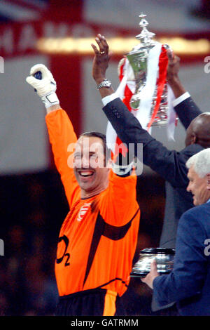 Soccer - AXA FA Cup - Final - Arsenal v Southampton. Arsenal's David Seaman and Patrick Vieira celebrate with the FA Cup trophy as guest of honour Sir Bobby Robson looks on Stock Photo