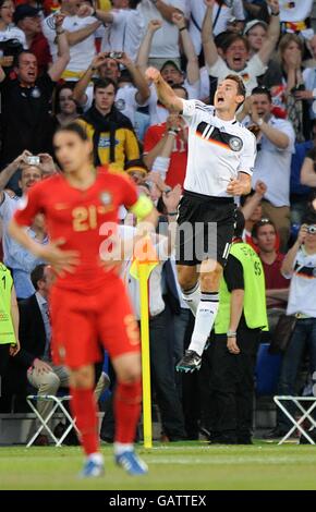 Germany's Miroslav Klose celebrates scoring his sides second goal of the game as Portugal's Nuno Gomes (left) stands dejected Stock Photo