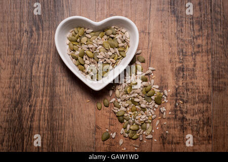 Heart shaped bowl with mixed nuts and seeds Stock Photo