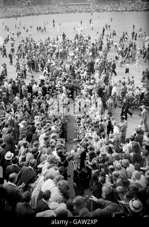 Australia's Don Bradman makes his way back to the pavilion through crowds of well-wishers after helping his team to victory with an unbeaten 173 on the final day. Australia set a new test record (which stood until 1975) by scoring 404 in their second innings to win the game Stock Photo