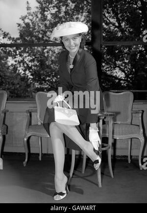 Smiling new arrival in London is Hollywood actress and dancer Cyd Charisse, pictured with a cameo-decorated handbag - at the Savoy Hotel this evening (Saturday) Stock Photo